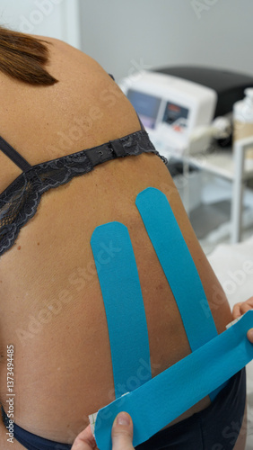 Obraz na płótnie Close-up of a physiotherapist using therapeutic patches on a woman’s back for pain treatment w salonie