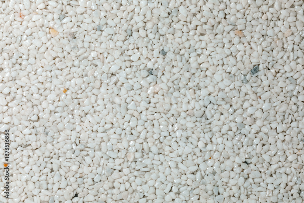 A close-up view of white gravel stones creating a textured and natural background. The small pebbles form an abstract pattern, commonly used for landscaping, construction, and decorative purposes A close-up view of white gravel stones creating a textured and natural background. The small pebbles form an abstract pattern, commonly used for landscaping, construction, and decorative purposes