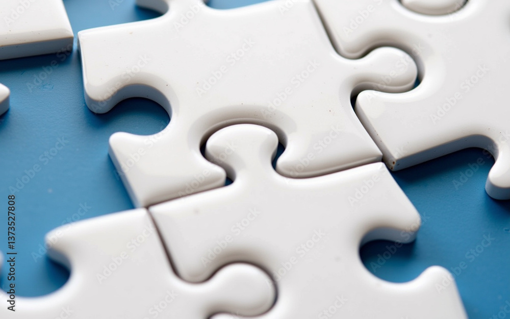 Group of white jigsaw puzzle pieces scattered on a blue surface. Group of white jigsaw puzzle pieces scattered on a blue surface.