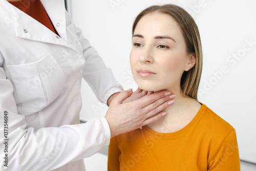 Foto Doctor palpates of woman's neck for diagnostics of thyroid diseases and hypothyroidism at medical clinic