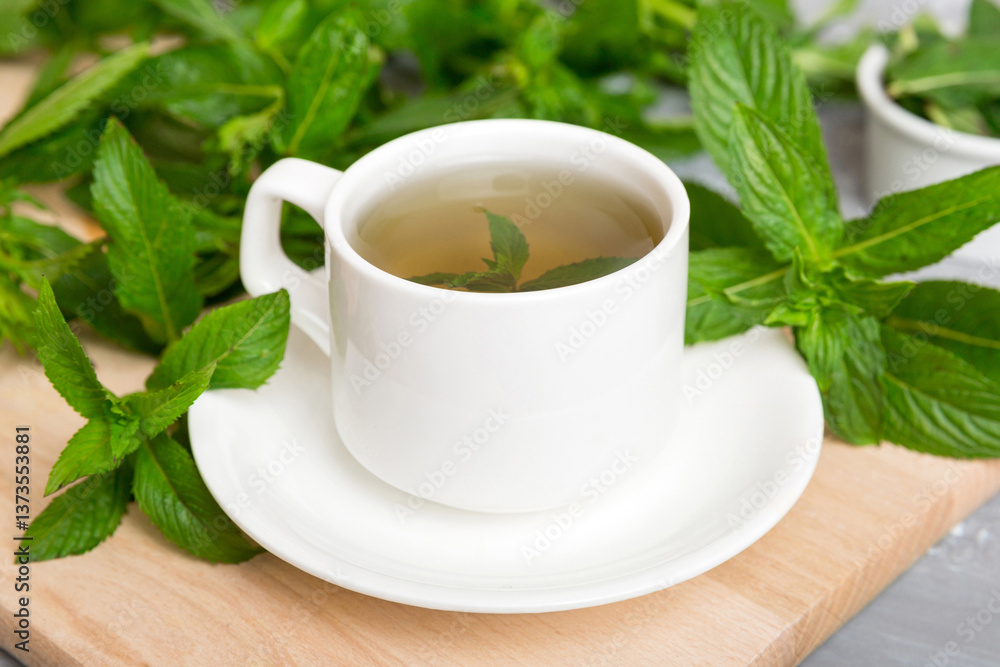 Cup of mint tea on table background. Green tea with fresh mint top view with copy space Cup of mint tea on table background. Green tea with fresh mint top view with copy space