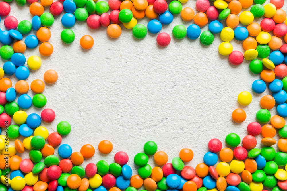 Obraz premium Mixed collection of colorful candy, on colored background. Flat lay, top view. frame of colorful chocolate coated candy