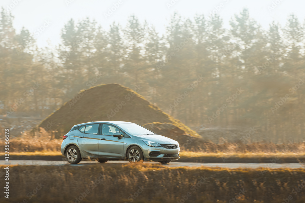 Modern black hatchback driving outdoors Modern black hatchback driving outdoors