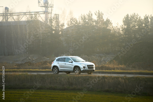 SUV driving through autumn landscape at dusk
