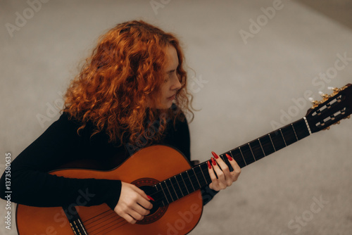 Canvastavla Young Woman Playing Acoustic Guitar with Focused Expression in Artistic Setting