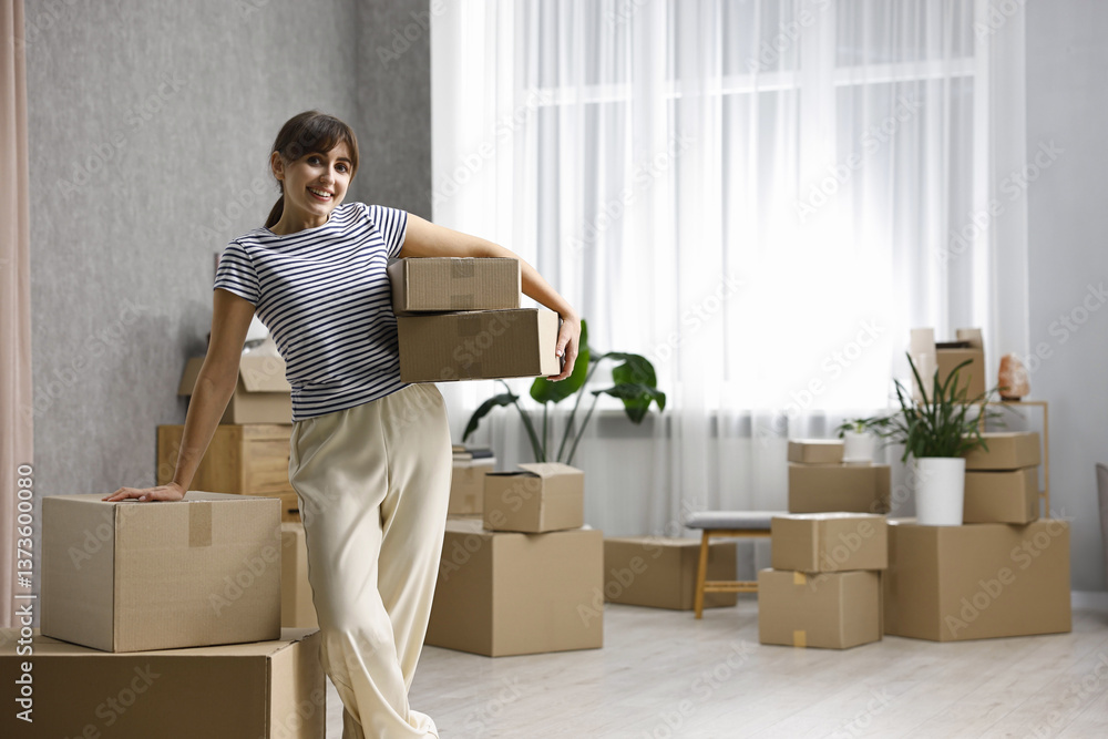 Moving day. Happy woman with cardboard boxes in her new home, space for text Moving day. Happy woman with cardboard boxes in her new home, space for text