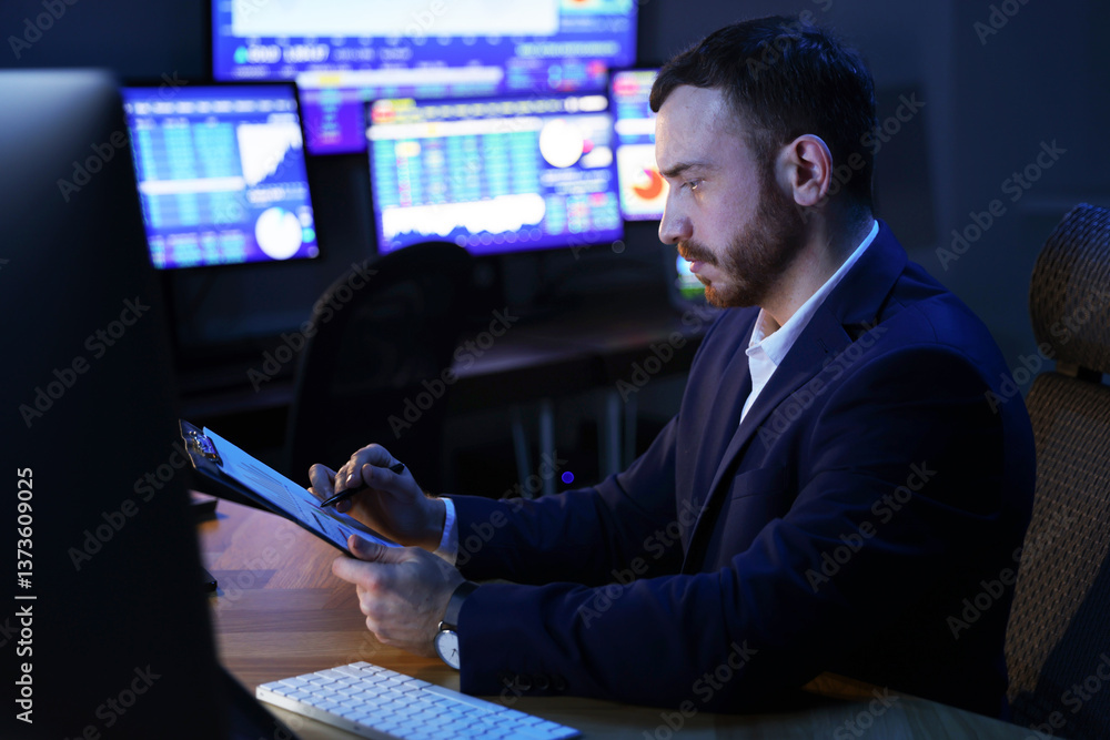 Fototapeta premium Financial trading specialist working in office at night