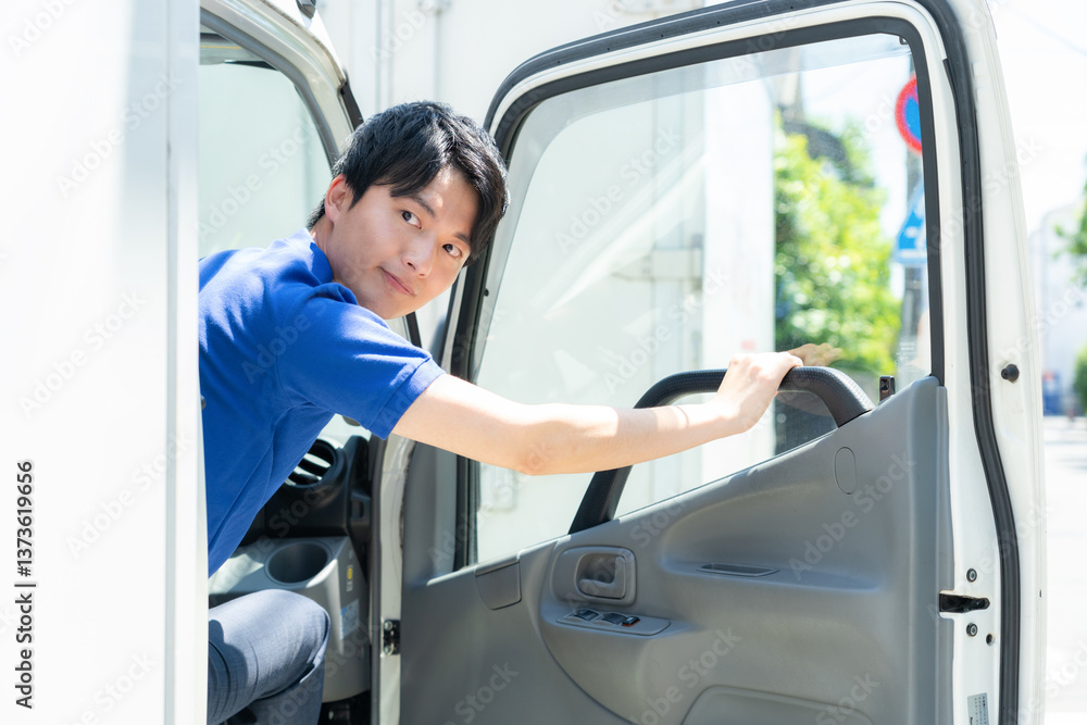 トラックで配達をする若い男性ドライバー トラックで配達をする若い男性ドライバー