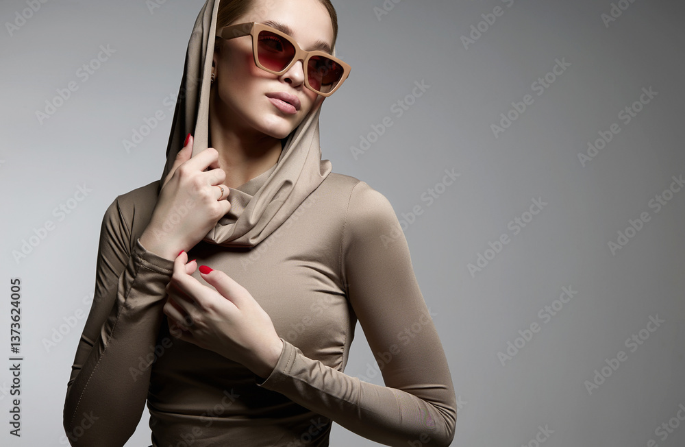 fashion portrait of Beautiful young woman in sunglasses and hood