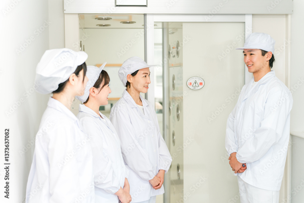 Obraz premium エアーシャワー・クリーンルームのある工場で働く作業員