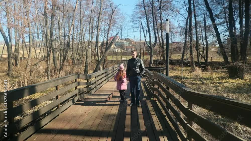 Dad with his daughter walking in the forest on a sunny day in cold weather Dad with his daughter walking in the forest on a sunny day in cold weather