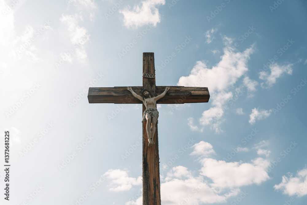 Crucifixion of Christ against the sky background. Catholicism, Christianity, faith concept. The initialism INRI Iesus Nazarenus, Rex Iudaeorum represents the Latin inscription in English translates to Crucifixion of Christ against the sky background. Catholicism, Christianity, faith concept. The initialism INRI Iesus Nazarenus, Rex Iudaeorum represents the Latin inscription in English translates to