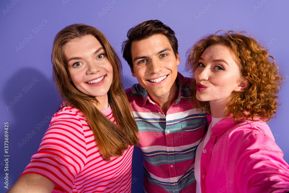 Three cheerful friends posing for a selfie showcasing their happiness and friendship against a vibrant purple background Three cheerful friends posing for a selfie showcasing their happiness and friendship against a vibrant purple background