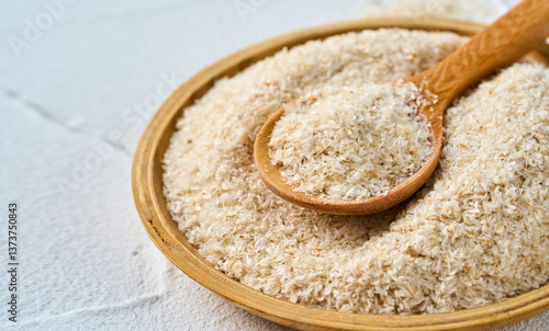 Billede på lærred closeup psyllium husk in wood bowl and spoon on white table background with copy