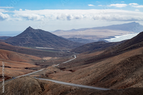 Serpentine coastal road cutting through volcanic valleys on Fuerteventura.