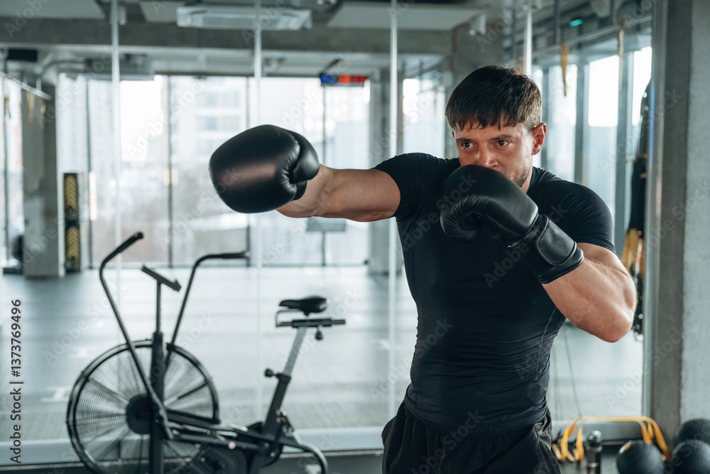 Punching, boxing training. Man is in the modern gym Punching, boxing training. Man is in the modern gym