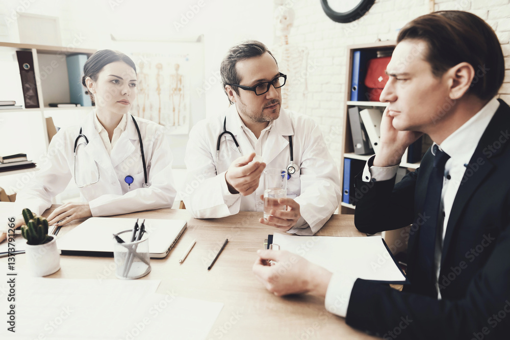 Experienced neurologist diagnoses male patient with headache at medical office. Experienced neurologist diagnoses male patient with headache at medical office.