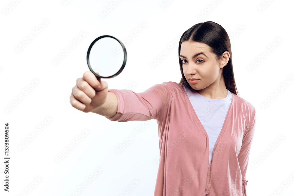 Young girl watches through magnifying glass. Young girl watches through magnifying glass.
