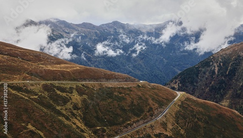 Scenic mountain road with misty clouds.