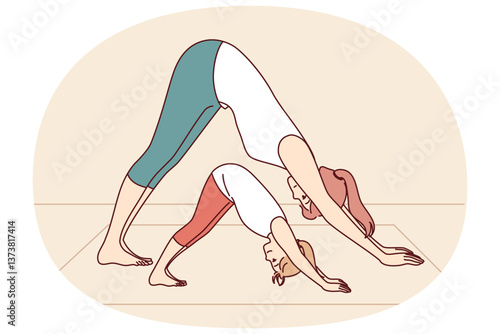 Mother and daughter are engaged in yoga and exercises, leading healthy lifestyle and learning good habits that improve well-being. Woman with little girl doing yoga pose adho mukha svanasana together