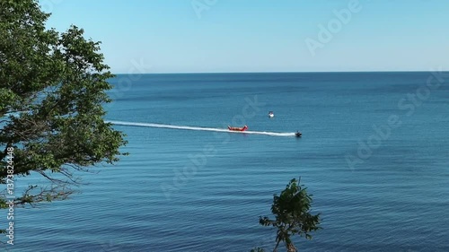 A motor boat carries happy people on an inflatable banana along the Black Sea. Krasnodar region. Vacation, relaxation, entertainment. High quality FullHD footage