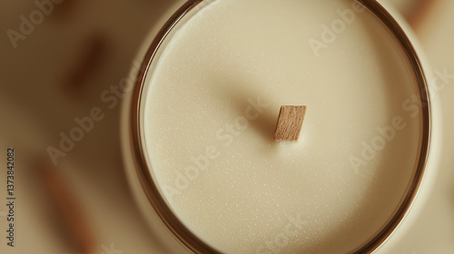 Close up of a scented candle with a wooden wick, set in a glass container, creating a cozy ambiance.