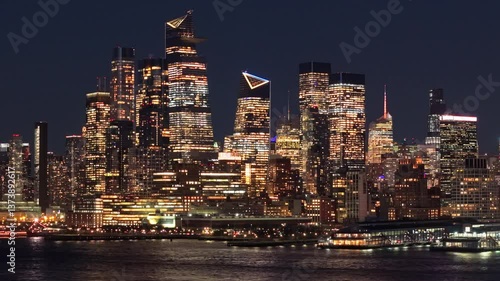 Aerial view of New York City skyline featuring Hudson Yards and Midtown Manhattan skyscrapers overlooking the Hudson River at night