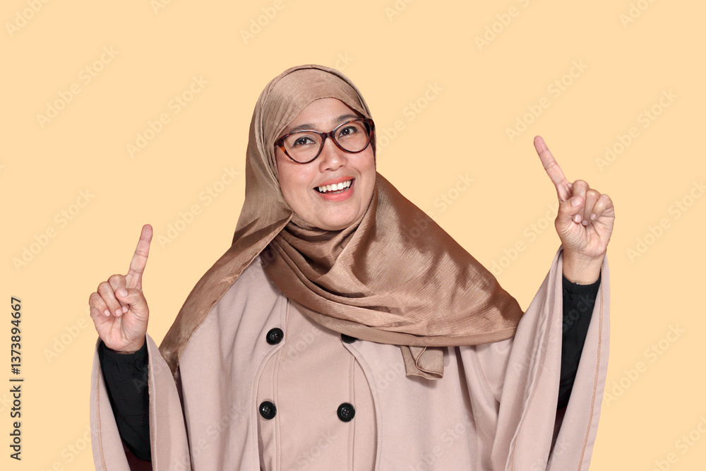 Cheerful Muslim Woman Pointing Up with Positive Expression Cheerful Muslim Woman Pointing Up with Positive Expression