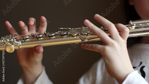 child playing on musical instrument flute close-up. classical music performed by wind instruments.