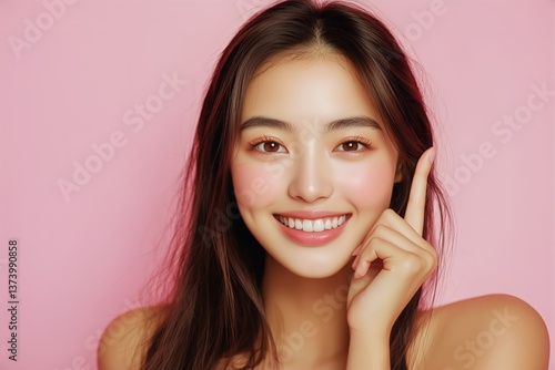 Smiling Young Woman With Long Hair Posing Against a Pink Background at a Stud...