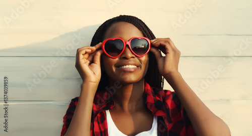 Принти на полотні Happy young african woman in red heart shaped glasses, beautiful girl smiling in