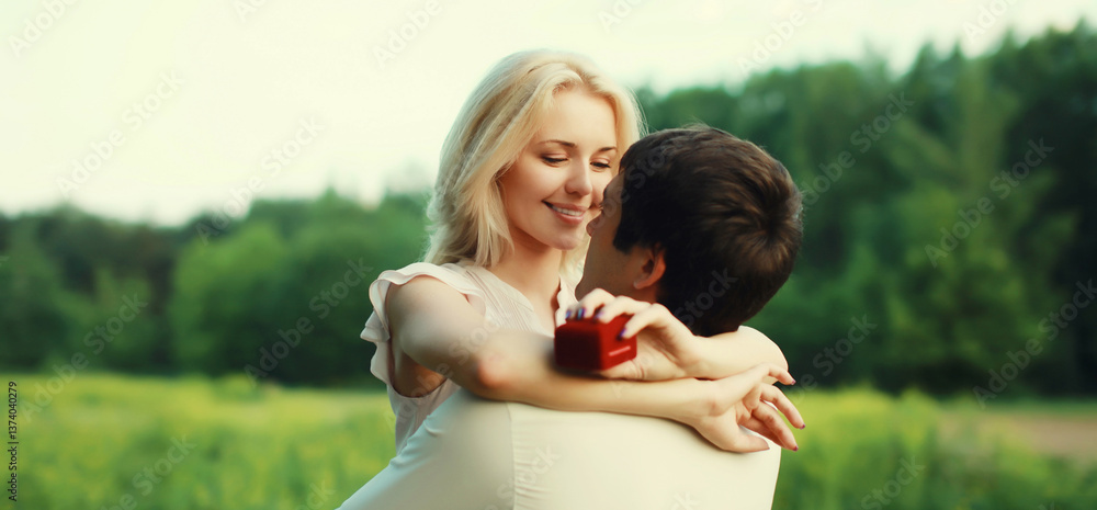 Fototapeta premium Wedding happy lovely young couple, man proposing a ring to his beloved woman outdoors in summer park