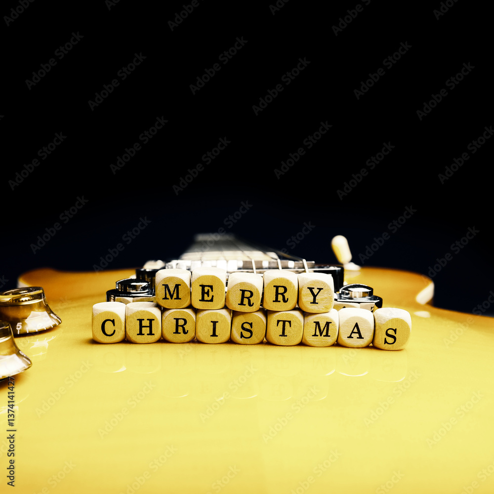 Φωτογραφία Wooden blocks with the inscription Merry Christmas on an old used vintage guitar