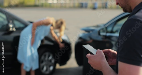 Man insurance agent inspects damage to a woman car and makes notes on a smartphone. Man inspecting broken car. Insurance concept.