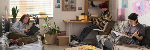 Photos Header image of three teenage friends studying in dorm room with separate activi