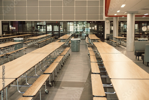 Trash cans setup between row of empty rectangle mobile cafeteria table with bench seats for easy sit close, spread out at middle school in Dallas, Texas, laminate top resists scratches and stains