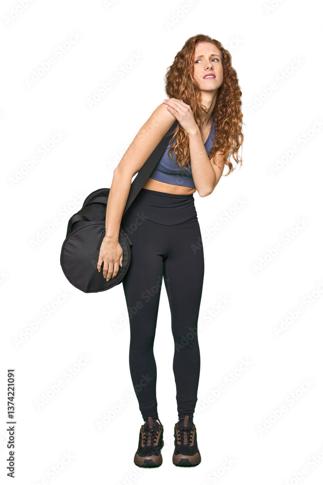 Fototapeta premium Full-body gym redhead having a shoulder pain.