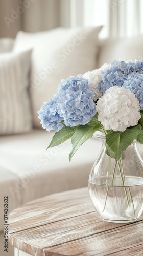 Bright blue and white hydrangeas in a vintage glass vase on a wooden table in a cozy living room with soft beige furniture