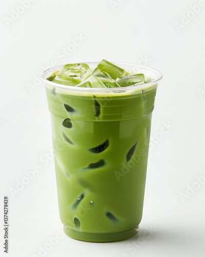 refreshing iced matcha latte in clear plastic cup against plain background