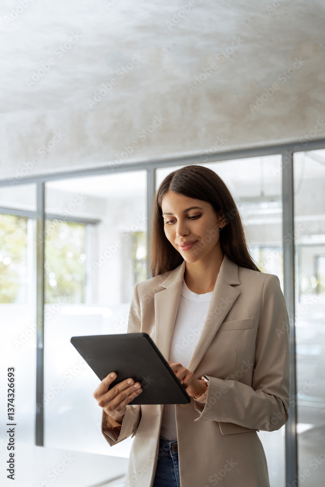 Female latin ceo leader, middle eastern business woman in office, holding digital device. Middle age manager specialist businesswoman using tablet pc at work for financial data analyzing. Vertical