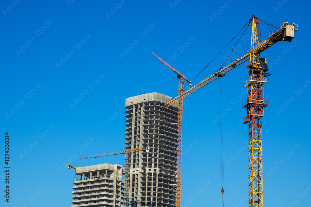 At a construction site, there is a bright blue sky in the background At a construction site, there is a bright blue sky in the background