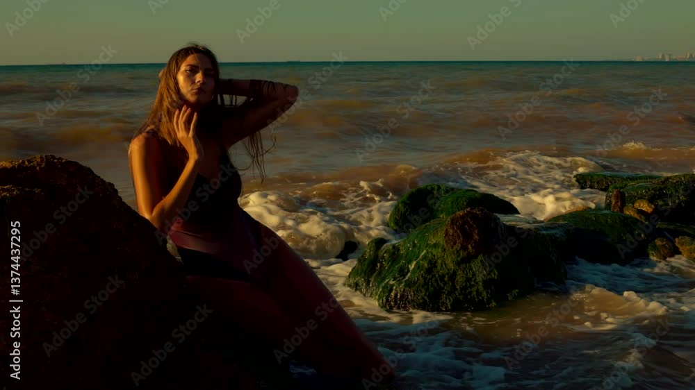 tall girl stands gracefully on beach sunrise her hair gently flowing in wind Waves crash around her while she poses near rocky outcrops embracing serene moment tall girl stands gracefully on beach sunrise her hair gently flowing in wind Waves crash around her while she poses near rocky outcrops embracing serene moment