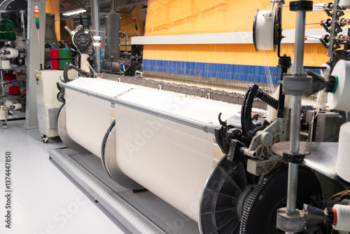 Industrial fabric production line. A loom at a textile factory. Fabric making process