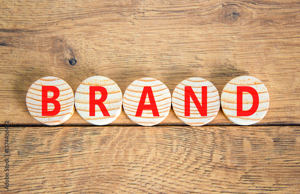 Fototapeta premium Brand symbol. Concept word Brand on beautiful wooden circles. Beautiful wooden table wooden background. Business brand concept. Copy space.