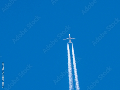 Commercial Passenger Aircraft with Two Distinct Contrails Crossing Deep Blue Atmospheric Sky
