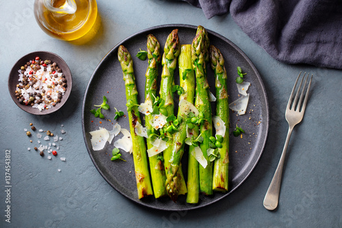 Cooked asparagus with parmesan cheese. Grey background. Close up. Top view.