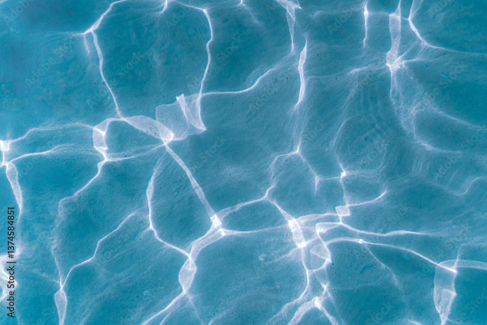 Obraz premium Background of transparent blue sea water glares under the rays of the sun. Sun glare at the bottom of the sea. Top view.