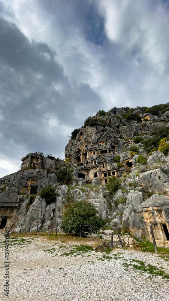 Fototapeta premium Ancient Lycian Rock Tombs In Myra, Turkey, Under Cloudy Winter Sky, Concept Of Archeology, Heritage Preservation, Tourism, Cultural History, And Sustainable Travel