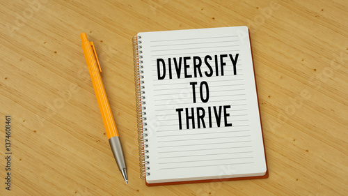 Diversify to thrive text message on note pad. Wooden background and pen 3d render.