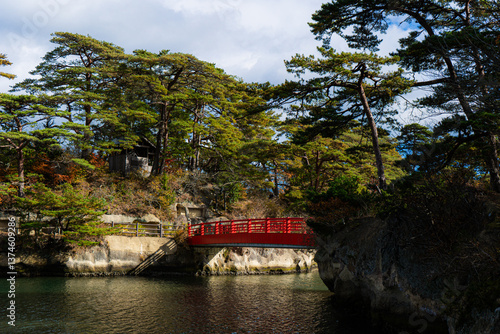 Old red wooden bridge leading to the pine trees in Matsushima Bay, Japan